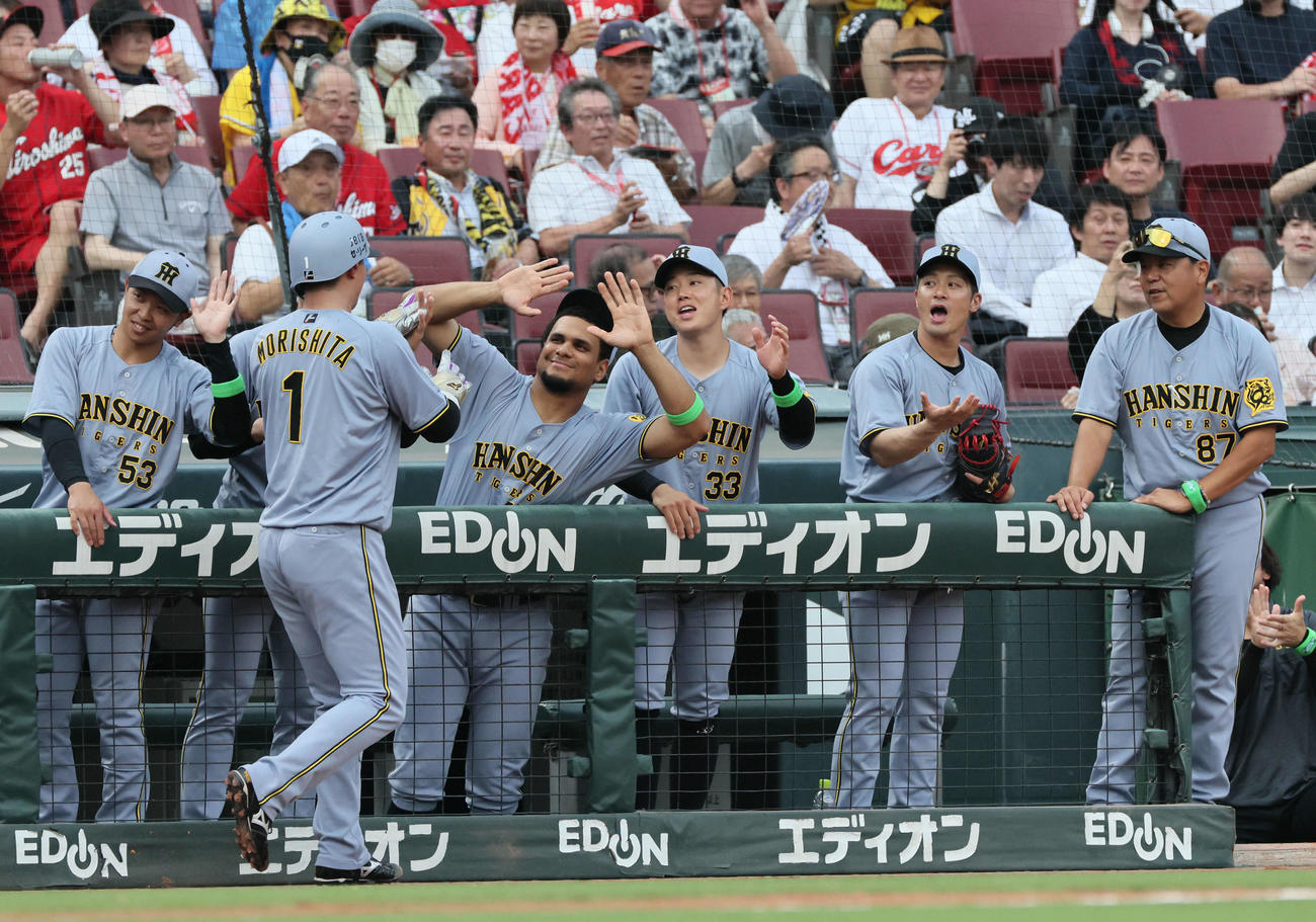 広島対阪神　1回表阪神1死二、三塁、佐藤輝の先制中前2点適時打で生還した森下を迎えるチームメート（撮影・加藤孝規）