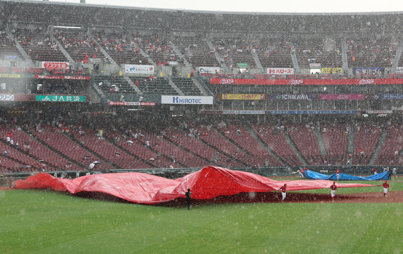 広島対阪神　急な大粒の雨でグラウンドにシートをかけるマツダスタジアムのグラウンドキーパー（撮影・加藤哉）