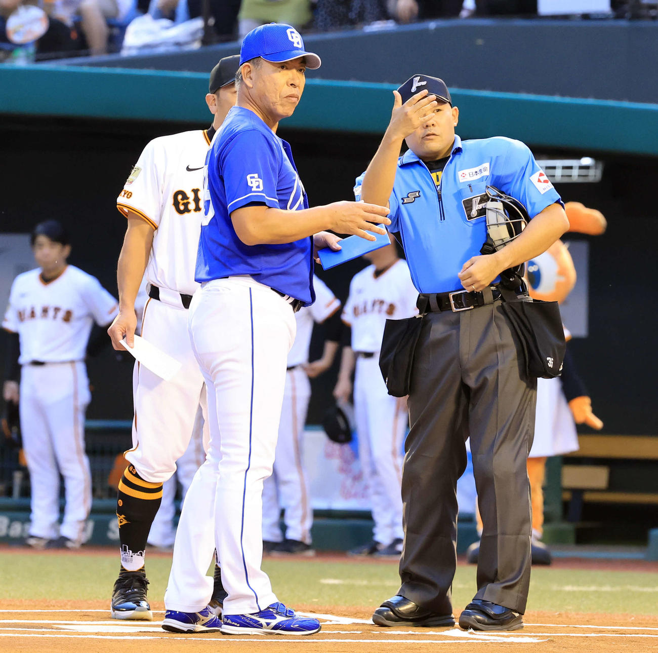巨人対中日　メンバー最終確認で中日井上監督（手前）は球審から説明を受ける（撮影・浅見桂子）