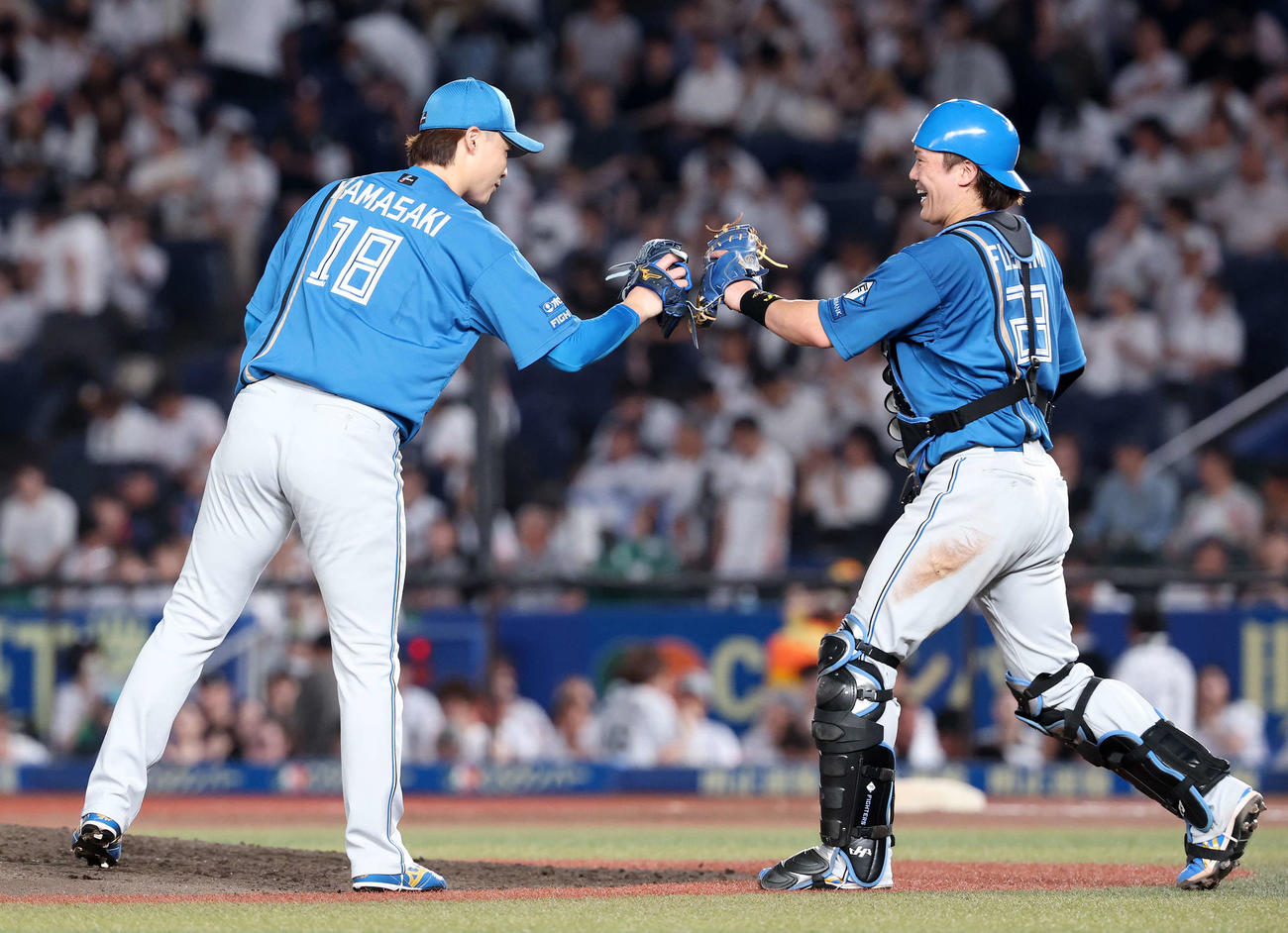 ロッテ対日本ハム　完投勝利しタッチする日本ハム山崎（左）と伏見（撮影・鈴木正人）
