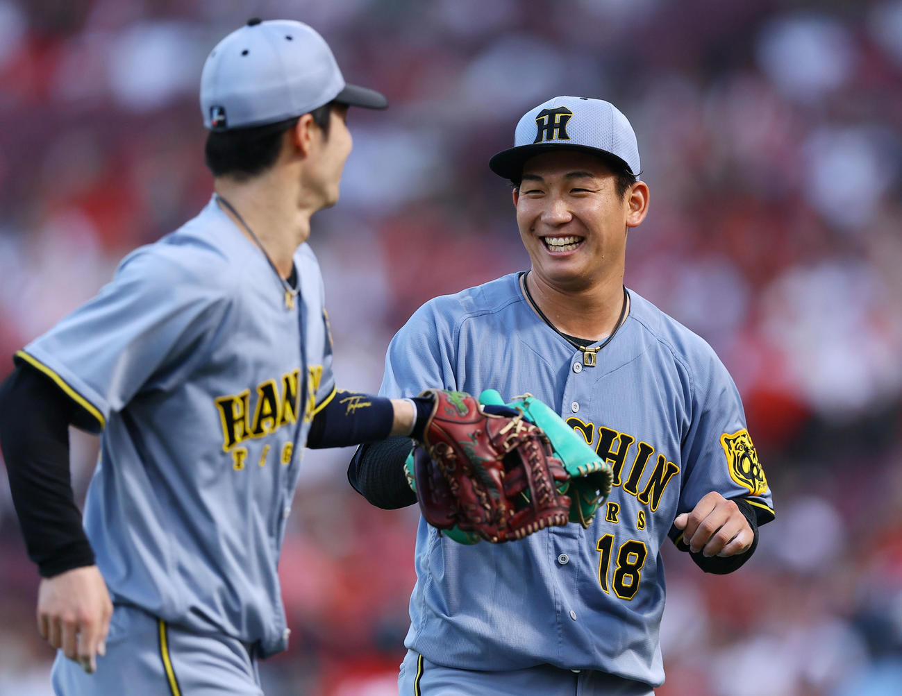 広島対阪神　3回を終え、好守を見せた中野（左）と笑顔でタッチを交わす阪神伊原（撮影・藤尾明華）