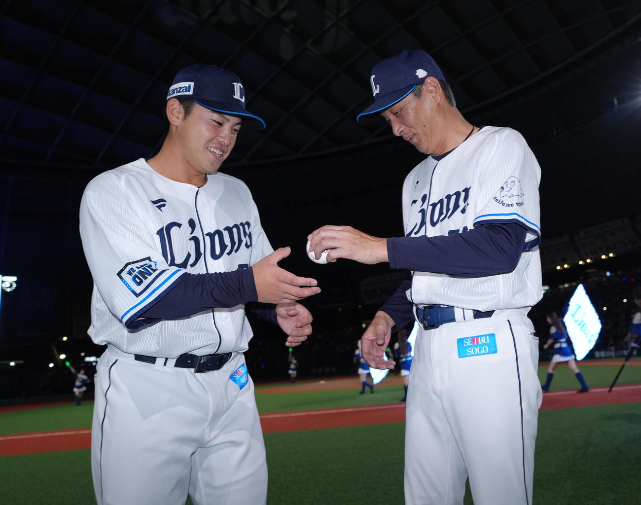 西武対楽天　8回にプロ初打席で初安打初打点をマークした西武仲三河は、西口監督（右）から記念球を受け取る（撮影・菅敏）