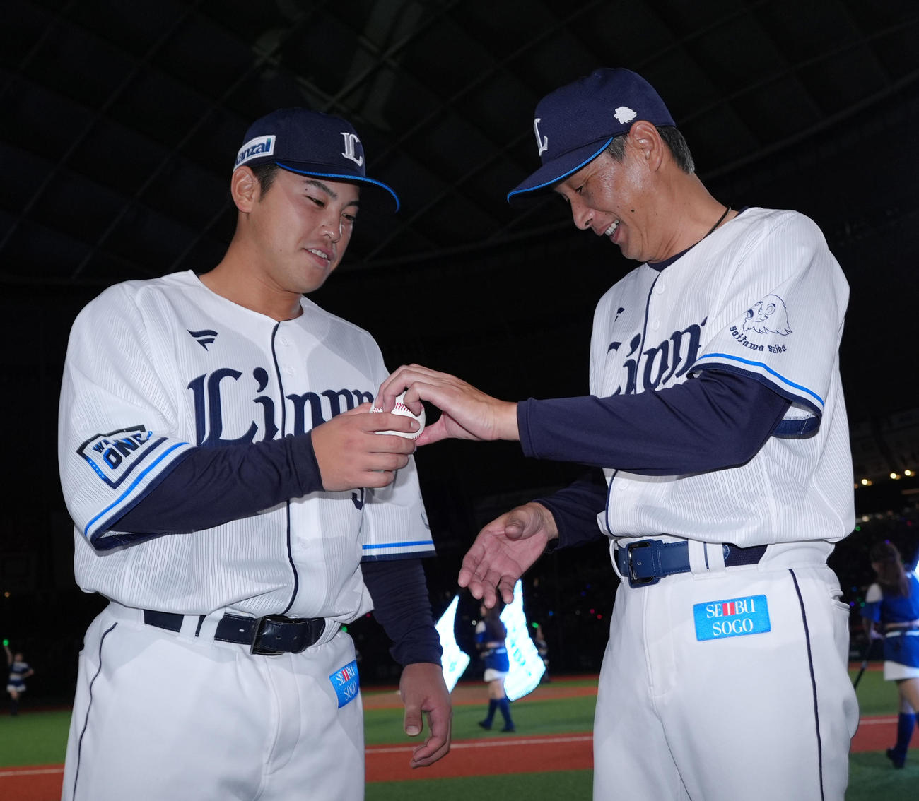 西武対楽天　8回にプロ初打席で初安打初打点をマークした西武仲三河は、西口監督（右）から記念球を受け取る（撮影・菅敏）