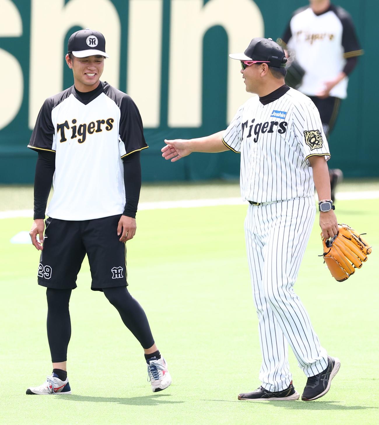 1軍に合流した高橋（左）は野村コーチに笑顔であいさつをする（撮影・上田博志）