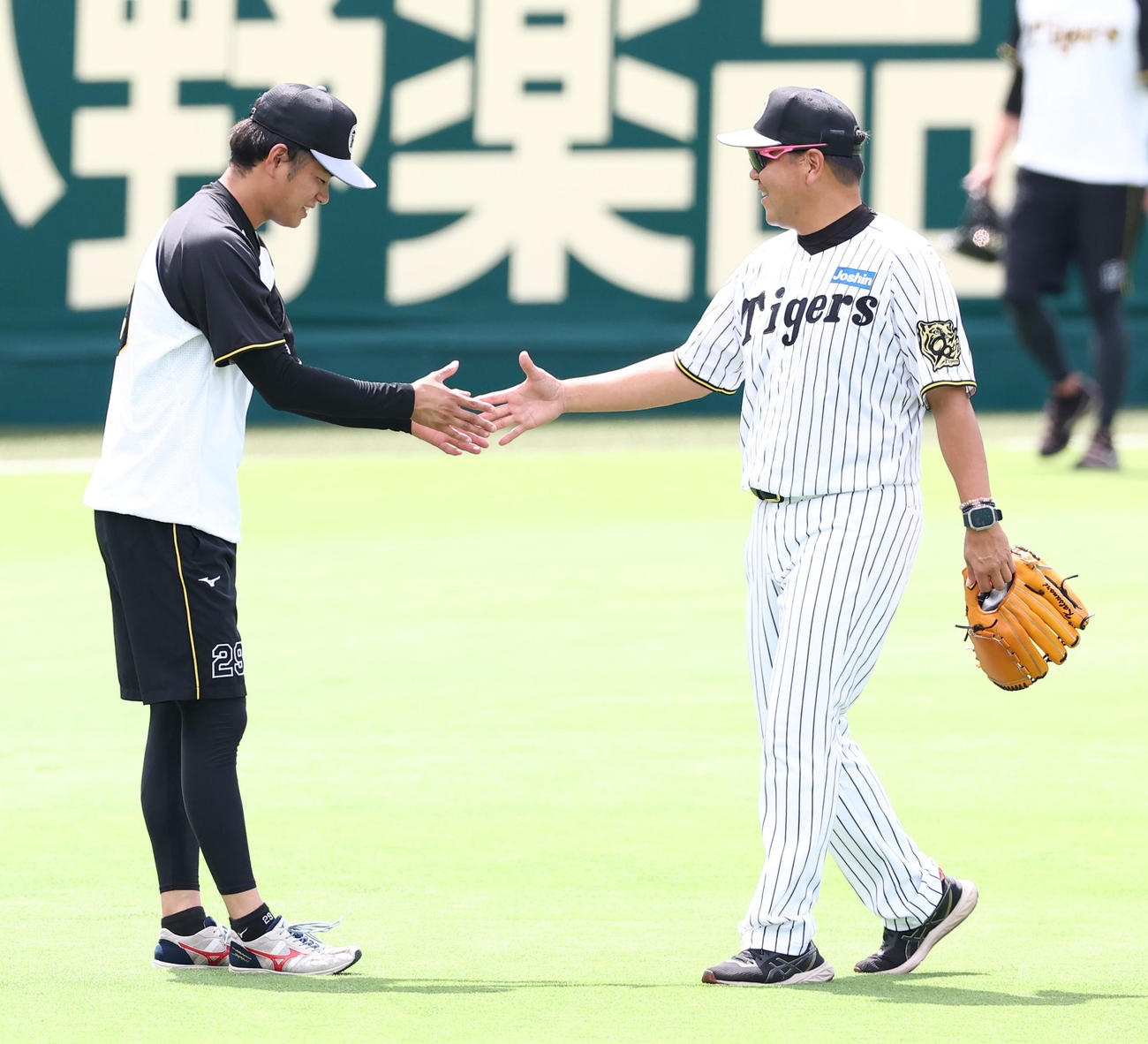 1軍に合流した阪神高橋（左）は野村コーチと握手を交わす（撮影・上田博志）