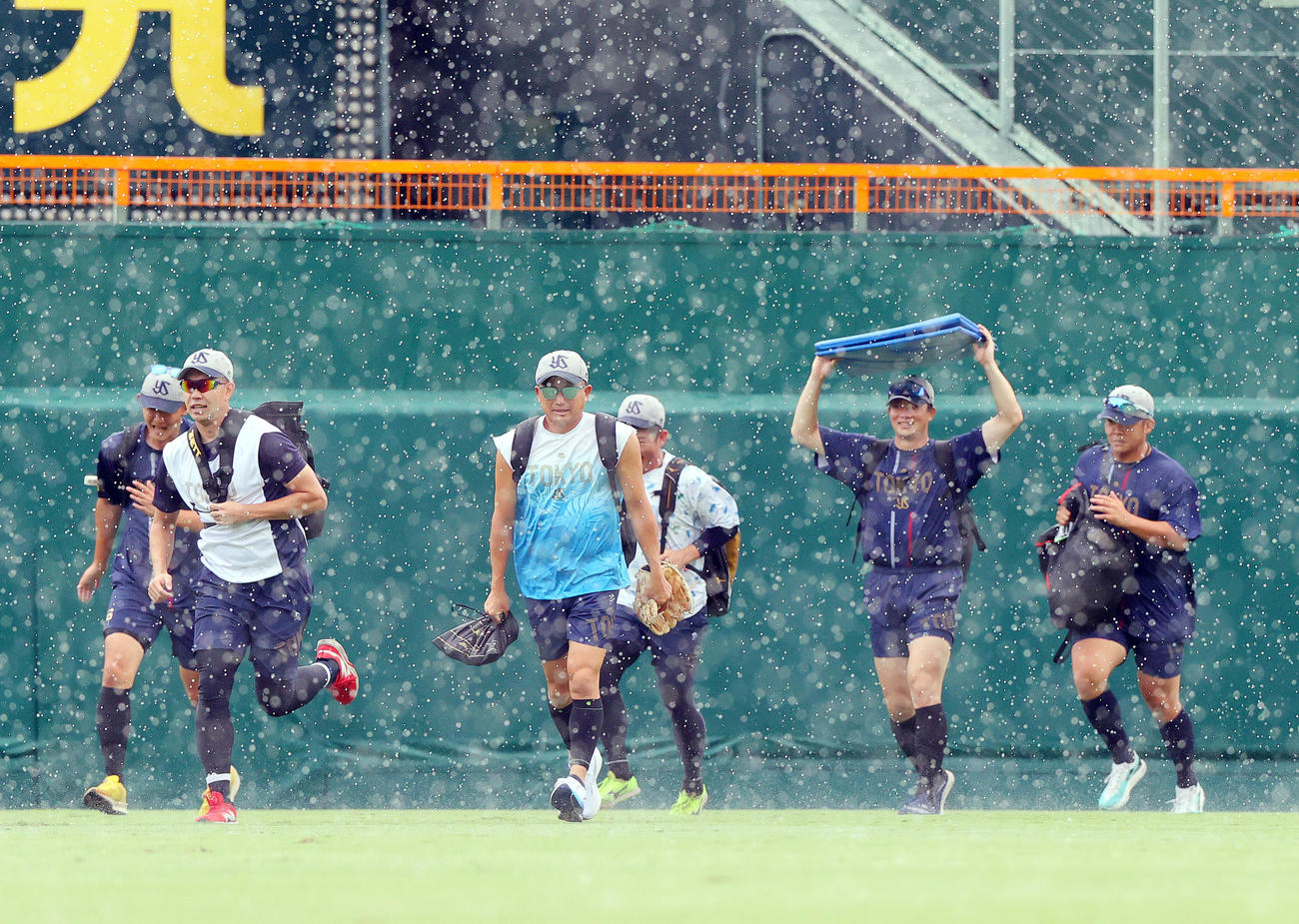阪神対ヤクルト　試合前の練習中、雨に見舞われ避難するヤクルト石川（左から3人目）ら（撮影・上山淳一）