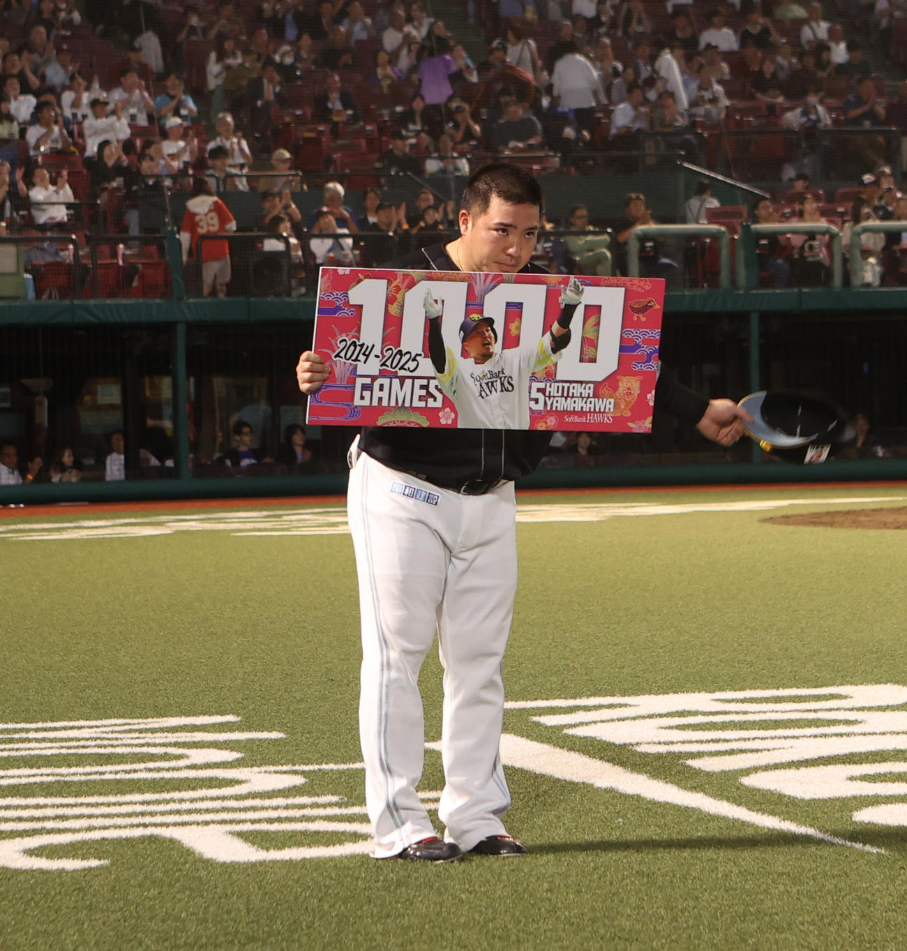 楽天対ソフトバンク　5回裏が終了し1000試合出場のボードを受け取る山川（撮影・水谷安孝）