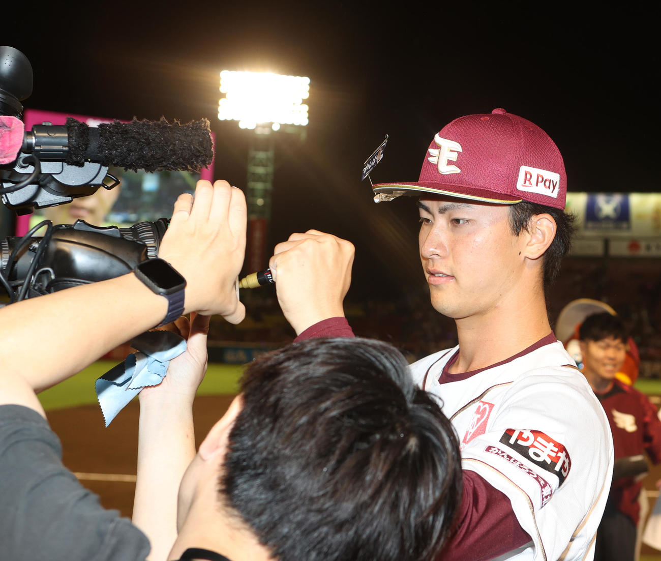 楽天対ソフトバンク　勝利を決めカメラにサインする古謝（撮影・水谷安孝）