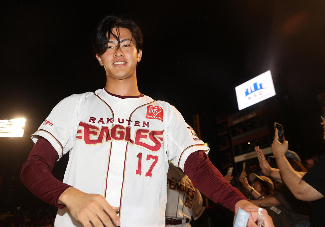 楽天対ソフトバンク　勝利を決めファンとハイタッチする古謝（撮影・水谷安孝）