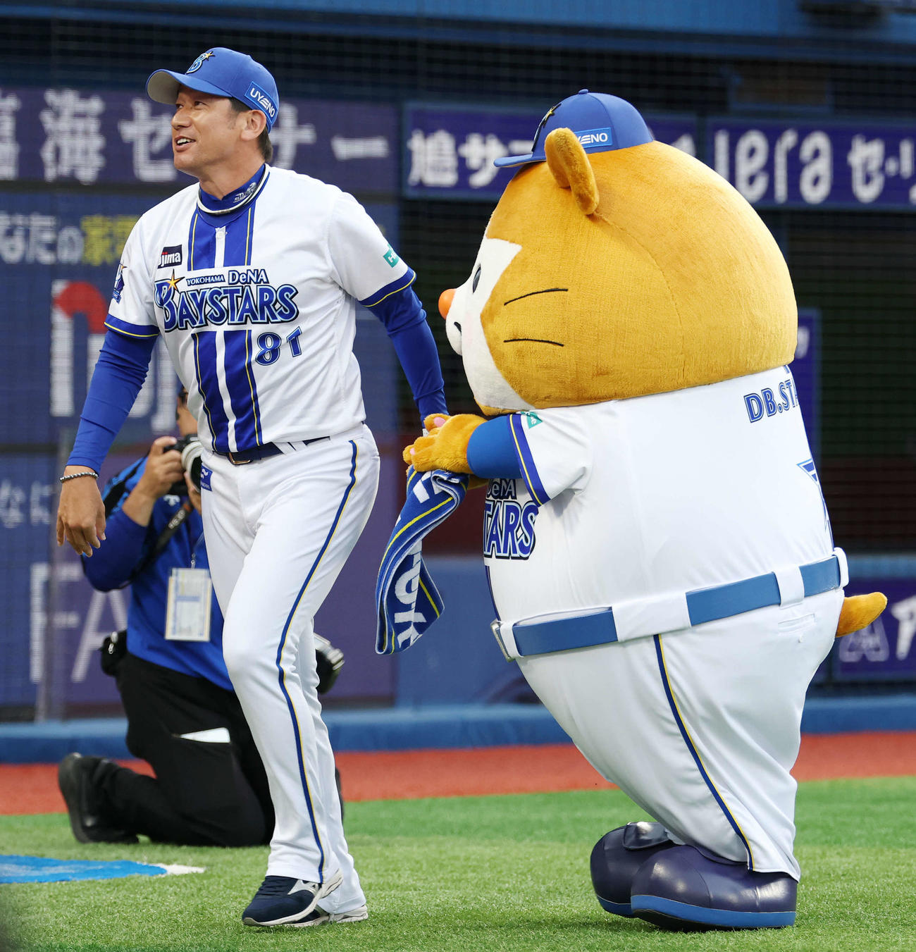 DeNA対巨人　試合前、DB．スターマンがつかみ損ねたメンバー表を拾い、渡したDeNA三浦監督（撮影・宮地輝）