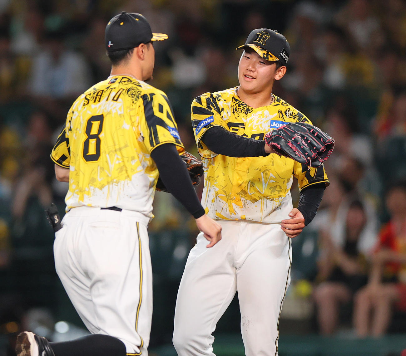 阪神対ヤクルト　3回表ヤクルト1死一塁、門別（右）は古賀を三ゴロ併殺に仕留め好守備を見せた佐藤輝を出迎える（撮影・上山淳一）