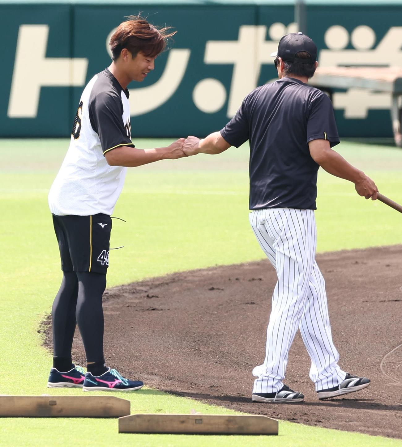 阪神対ヤクルト　藤本コーチ（右）とグータッチする島本（撮影・上田博志）＝2025年7月12日、甲子園球場