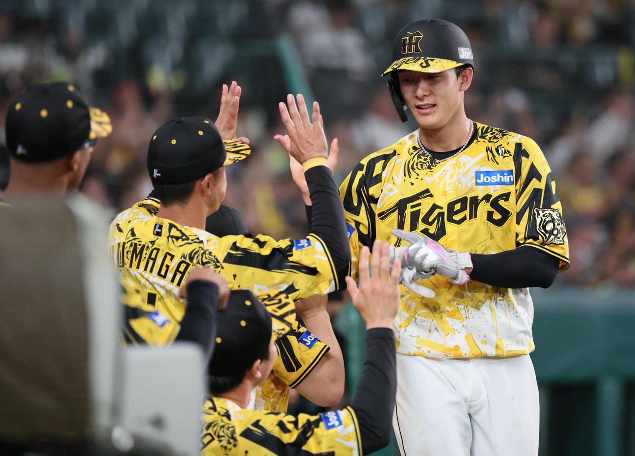 阪神対ヤクルト　8回裏阪神2死二塁、小幡は坂本の右越え適時三塁打で生還し、ナインに迎えられる（撮影・宮崎幸一)