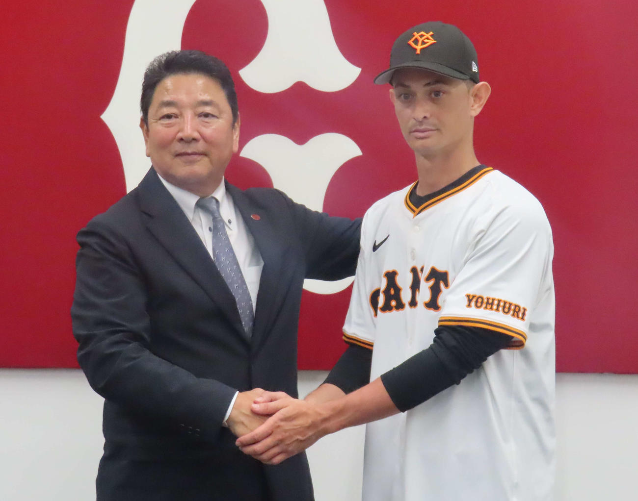 入団会見に臨み、握手を交わす巨人乙坂（右）と吉村編成本部長（（撮影・水谷京裕））