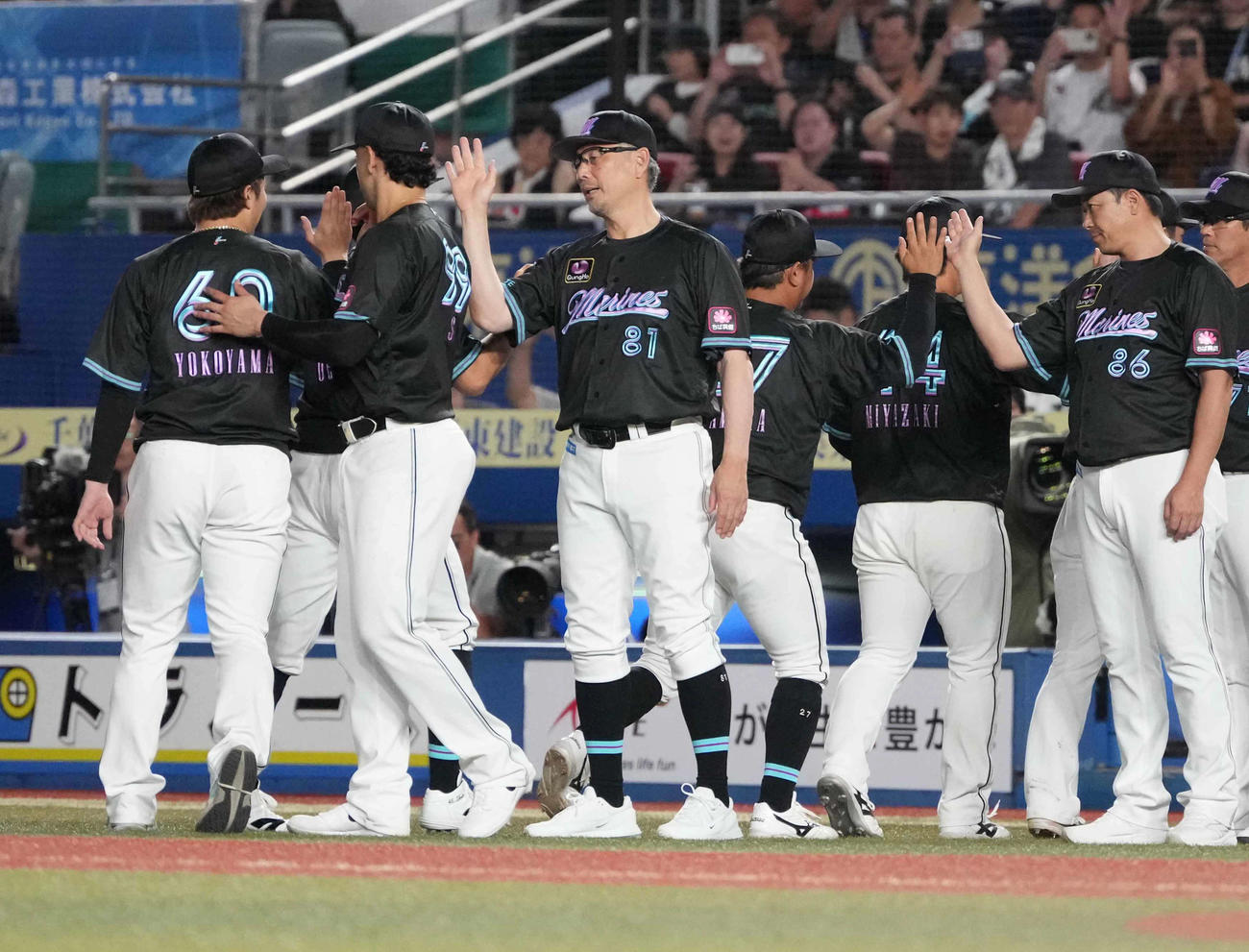 ロッテ対西武　ナインとハイタッチするロッテ吉井監督（中央）（撮影・小沢裕）