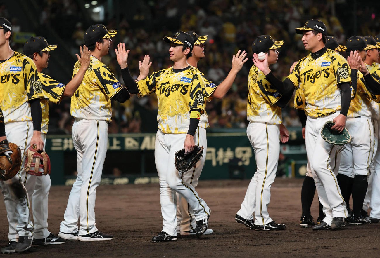 阪神対ヤクルト　岩崎（右）から勝利球を受け取る伊藤将。左から2人目は藤川監督（撮影・宮崎幸一)