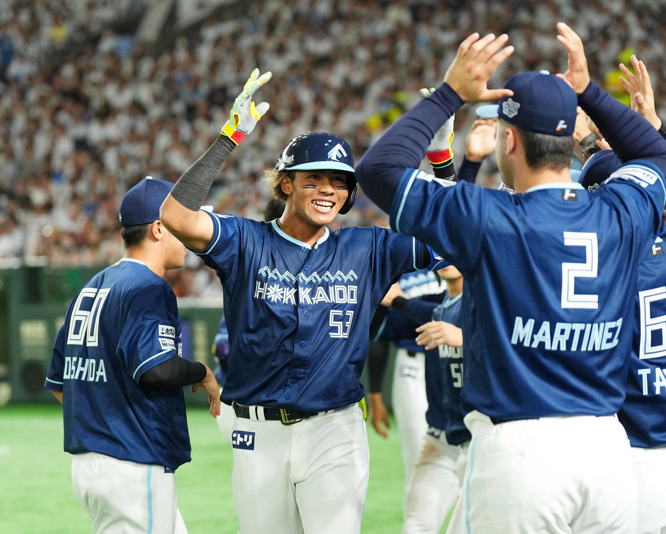 西武対日本ハム　5回表日本ハム2死二塁、左越えに先制の2点本塁打を放ち、ナインに迎えられる水谷（中央）（撮影・菅敏）