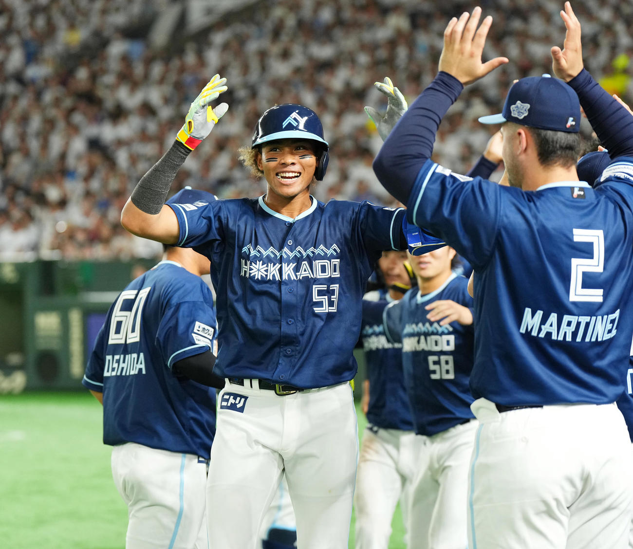 西武対日本ハム　5回表日本ハム2死二塁、左越えに先制の2点本塁打を放ち、ナインに迎えられる水谷（中央）（撮影・菅敏）