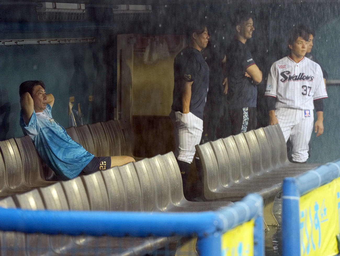 雨が降りしきる中、グラウンドを見つめるヤクルト高津監督（撮影・たえ見朱実）