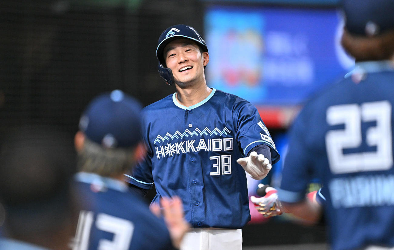 西武対日本ハム　6回表日本ハム1死一、二塁、敵失で生還した二塁走者石井は（中央）は笑顔でチームメートとタッチをかわす（撮影・滝沢徹郎）