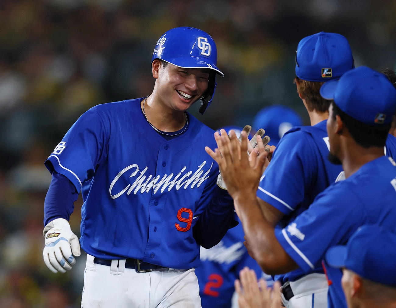 阪神対中日　6回表中日2死一、三塁、上林の2点適時二塁打で生還し、ナインとタッチを交わす石伊（撮影・藤尾明華）