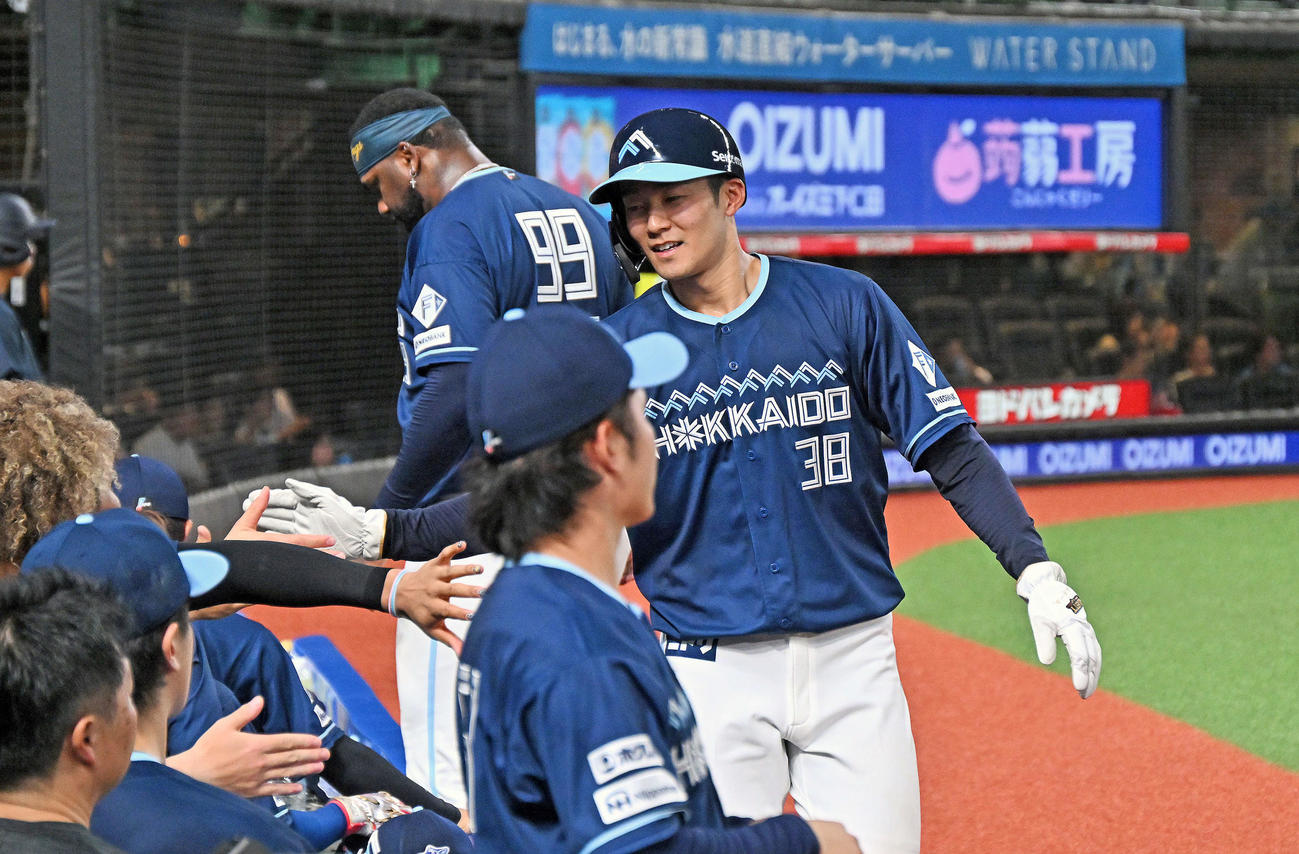 西武対日本ハム　3回表日本ハム1死三塁、水野の適時打で生還した石井（右）はチームメートとタッチをかわす（撮影・滝沢徹郎）