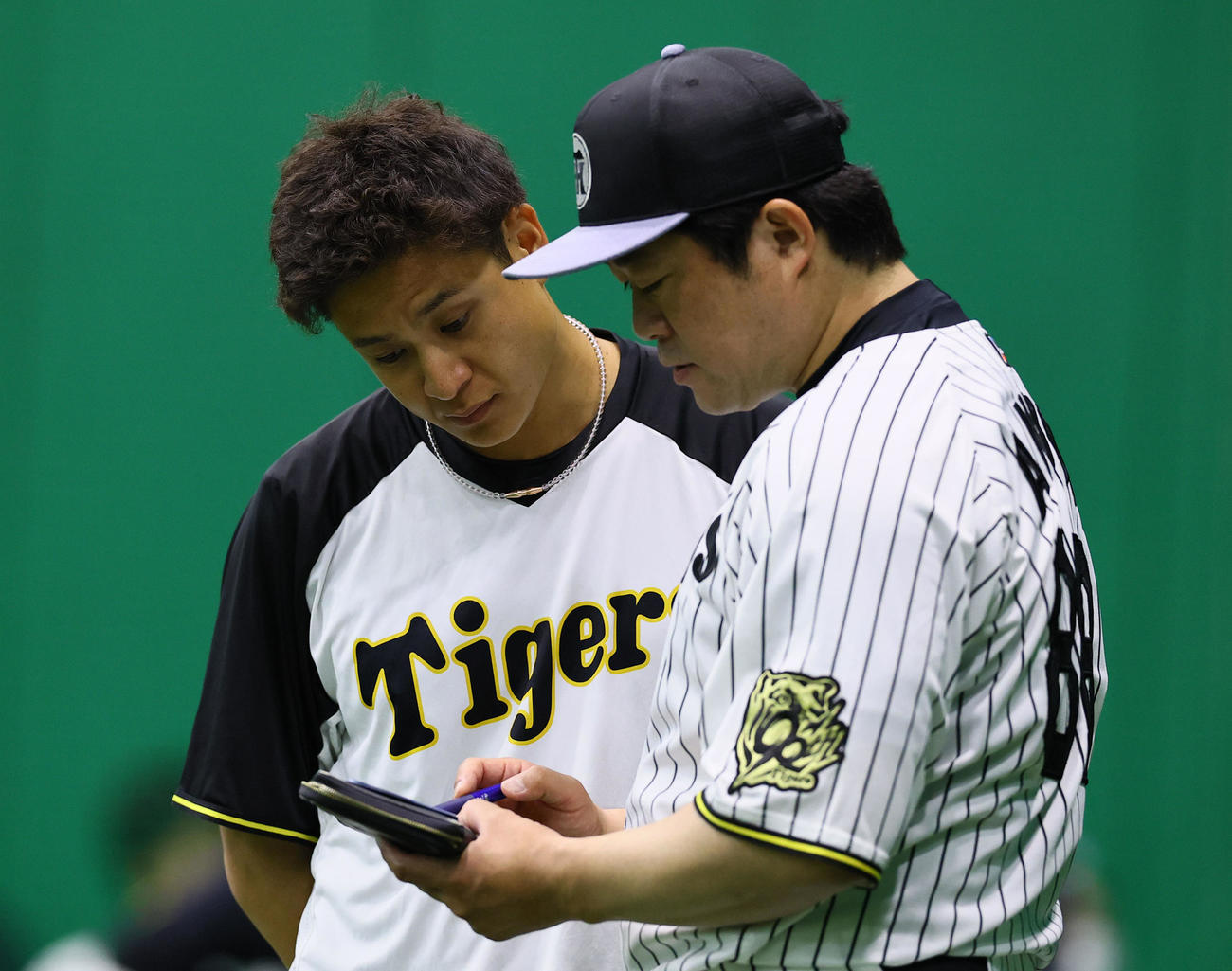阪神対中日　試合が中止となり、安藤投手チーフコーチ（右）と話しをする阪神大竹（撮影・藤尾明華）