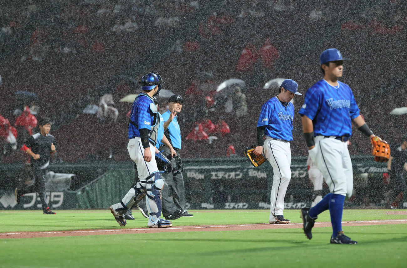 広島対DeNA 6回裏広島1死一塁、打者小園の時、雨脚が強くなりまたも中断、、ベンチに引き揚げるDeNAナインら（撮影・加藤孝規）