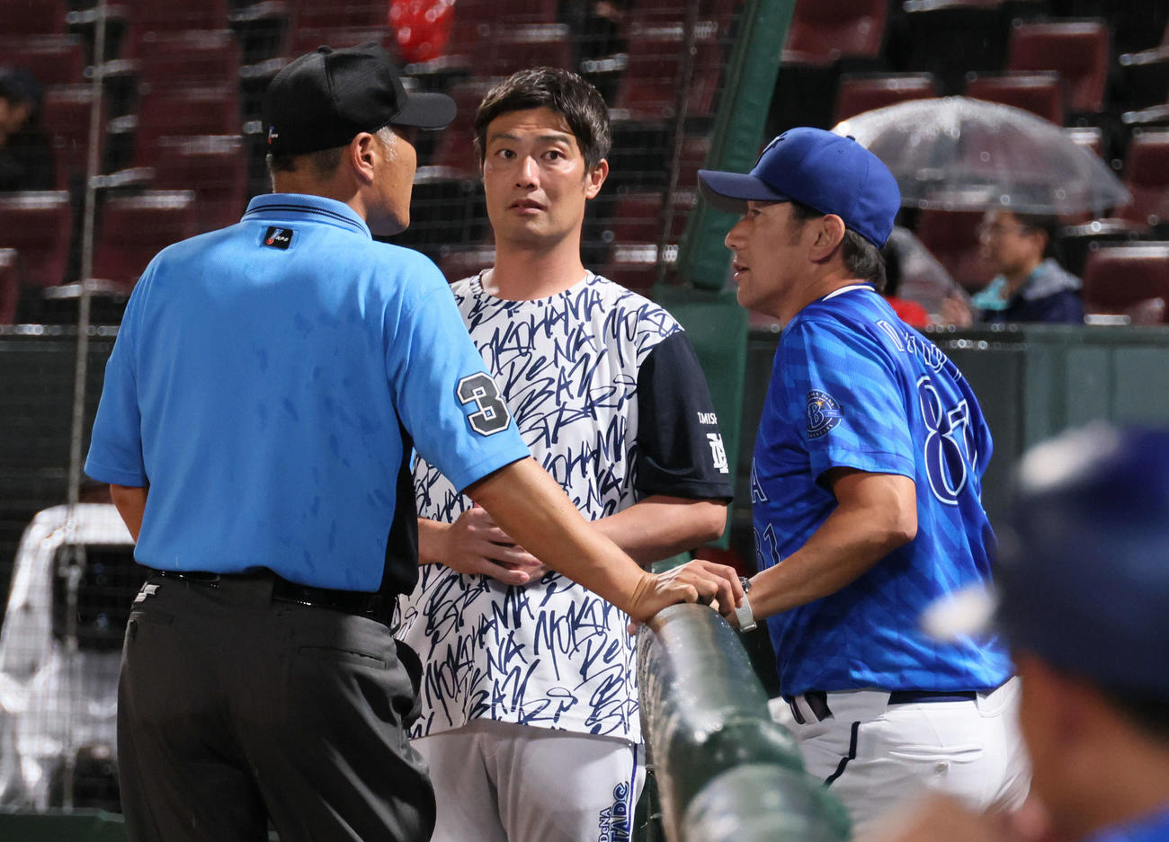 広島対DeNA　試合中断中、審判と話し合う三浦監督（右）（撮影・加藤孝規）