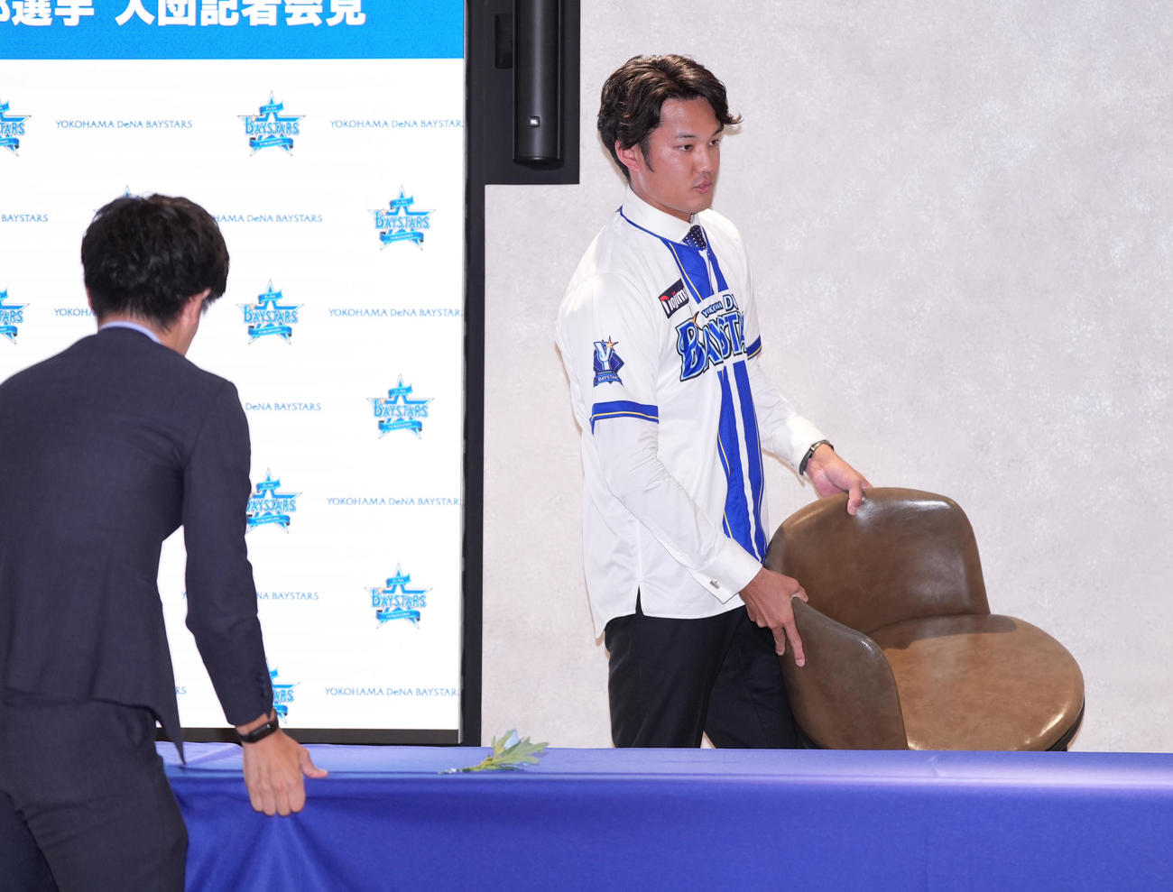 入団会見後、フォトセッションの準備を手伝うDeNA藤浪（右）（撮影・鈴木みどり）