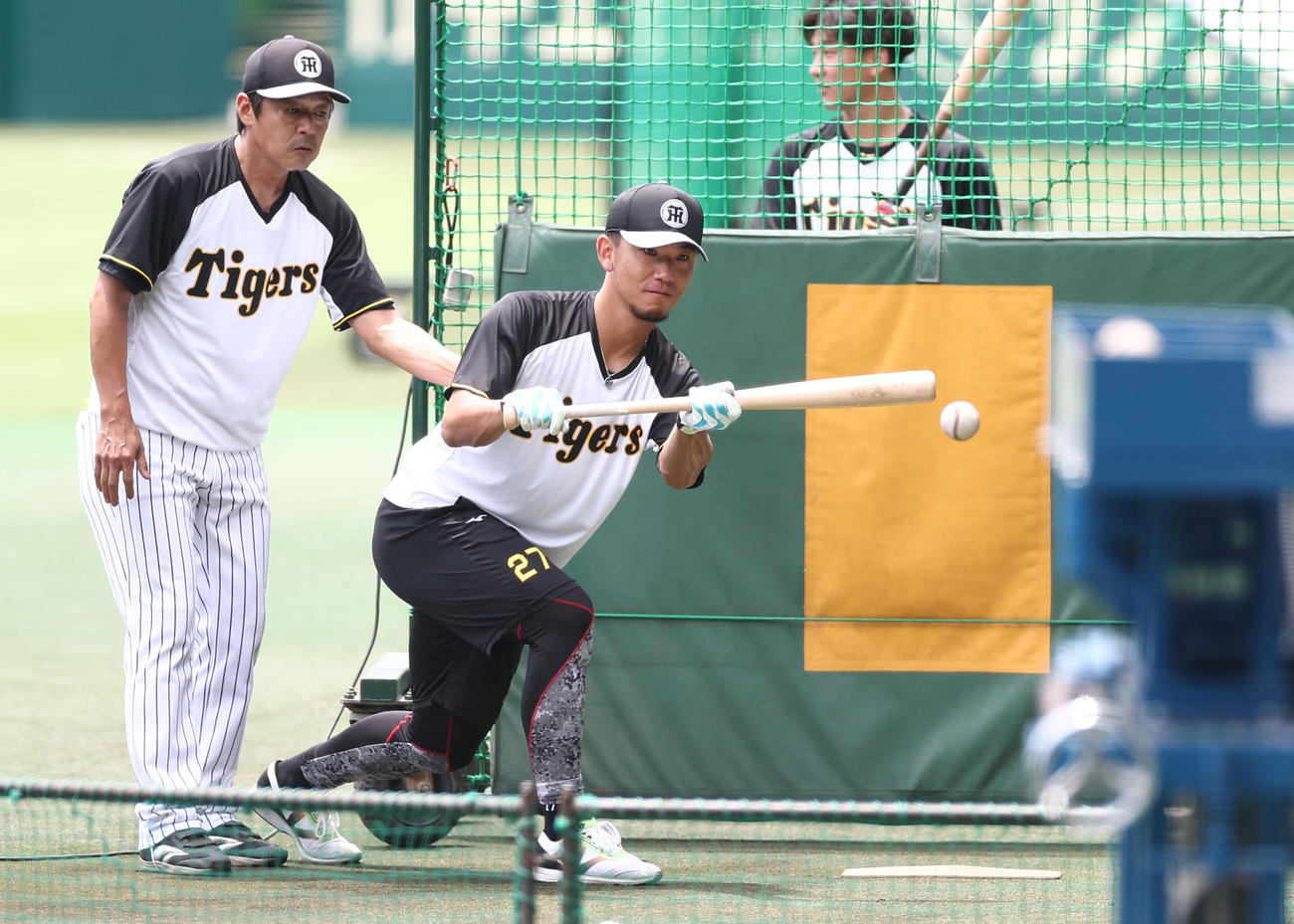 藤本コーチの指導を受けながらバント練習をする伊藤将（撮影・上田博志）