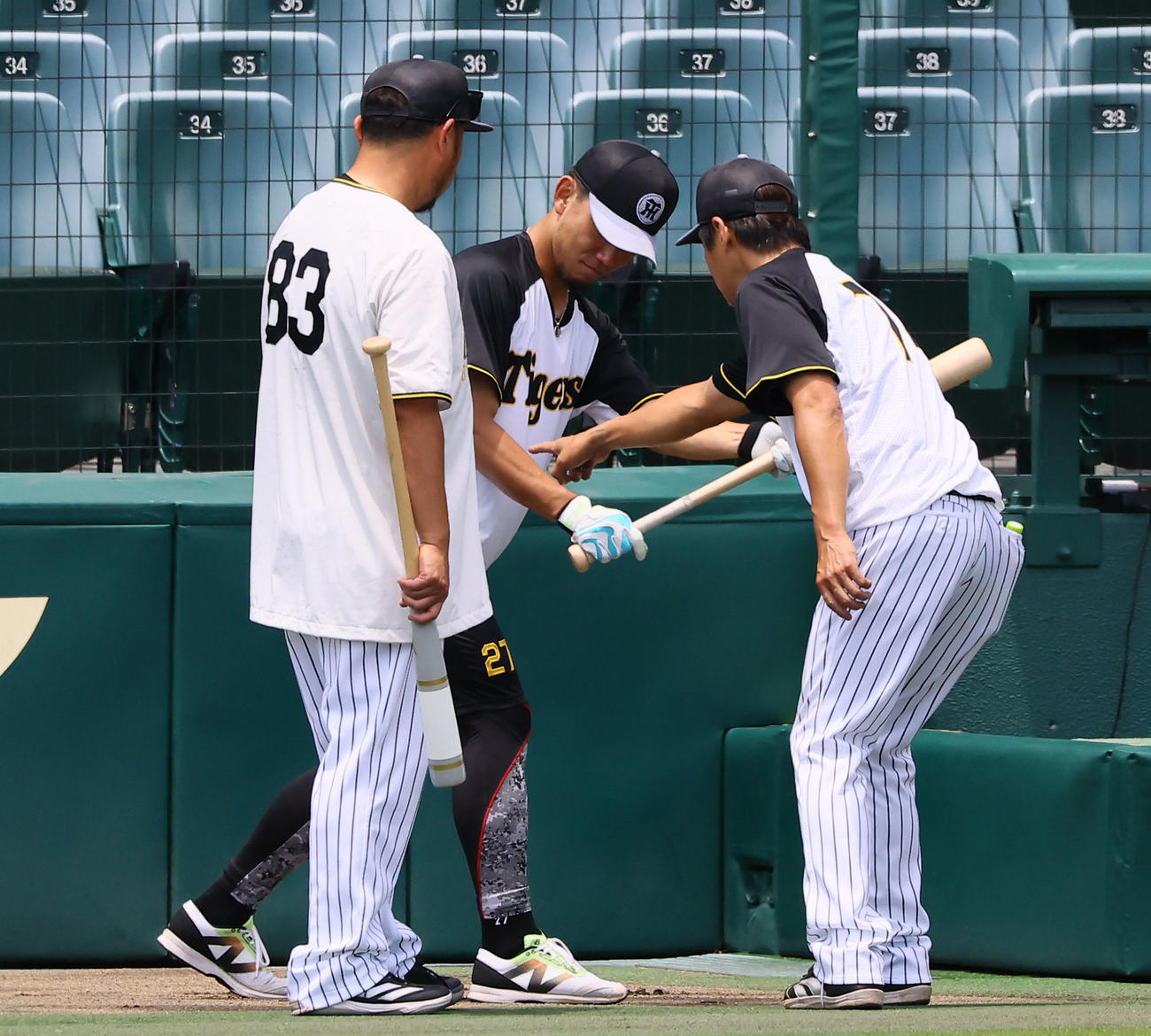 藤本総合コーチ（右）と小谷野1軍打撃コーチにバントの指導を受ける阪神伊藤将（中央）（撮影・藤尾明華）