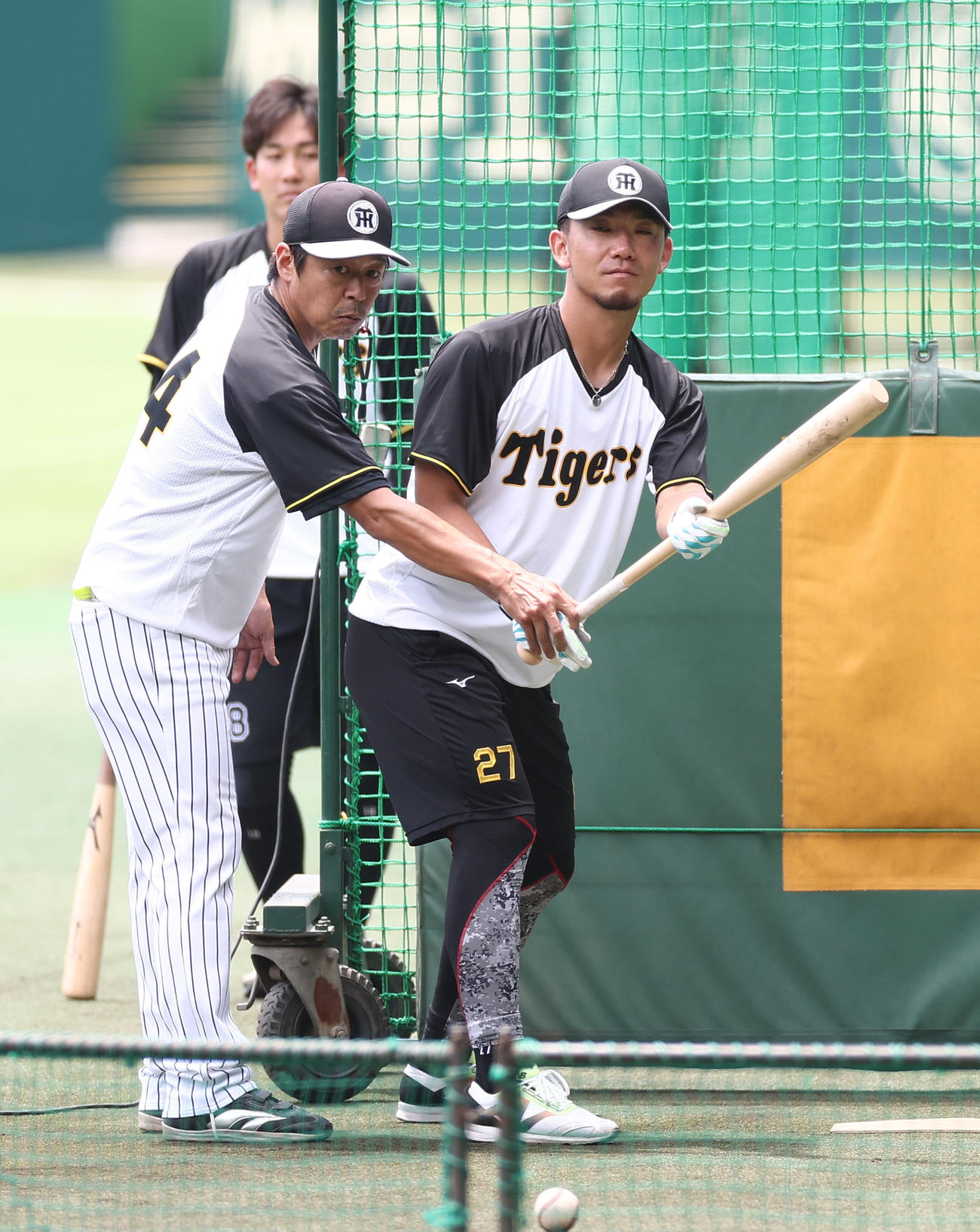 藤本コーチの指導を受けながらバント練習をする伊藤将（撮影・上田博志）