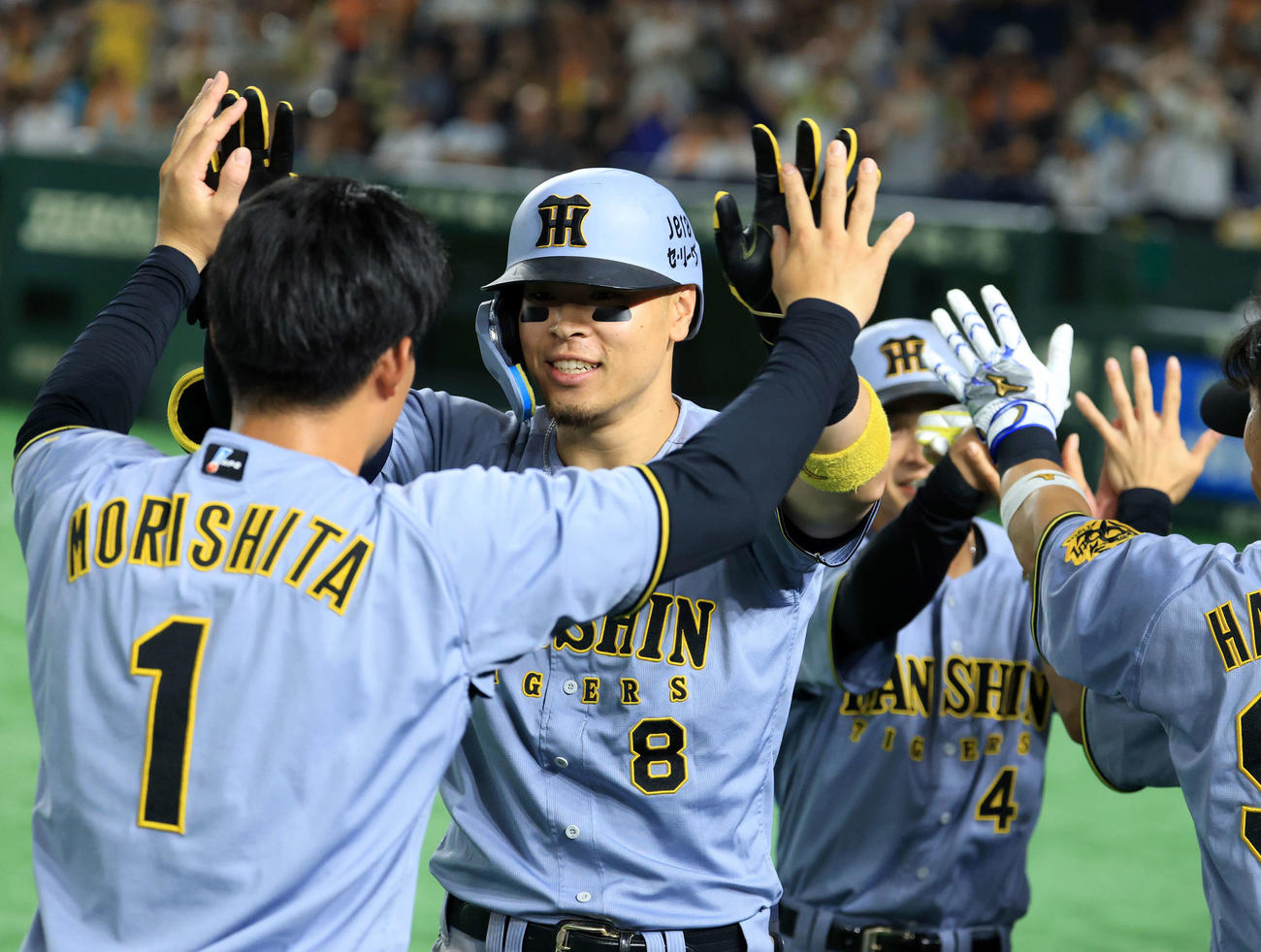 巨人対阪神　11回表阪神1死一塁、佐藤輝は2点本塁打を放ち森下らナインとハイタッチ（撮影・浅見桂子）