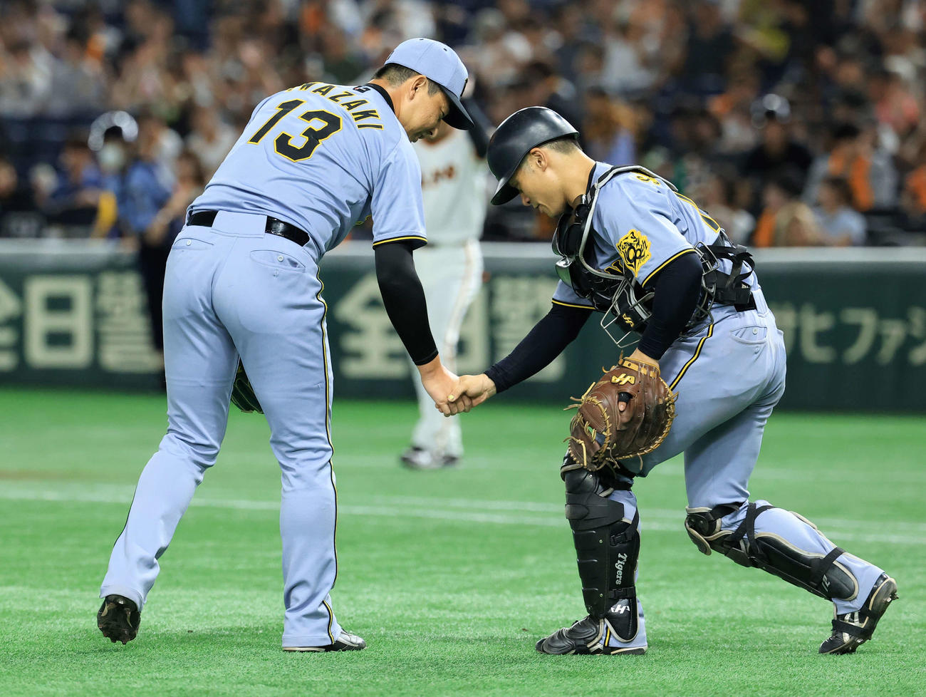 巨人対阪神　11回裏巨人の攻撃を抑えた岩﨑（左）は坂本とハイタッチ（撮影・浅見桂子）
