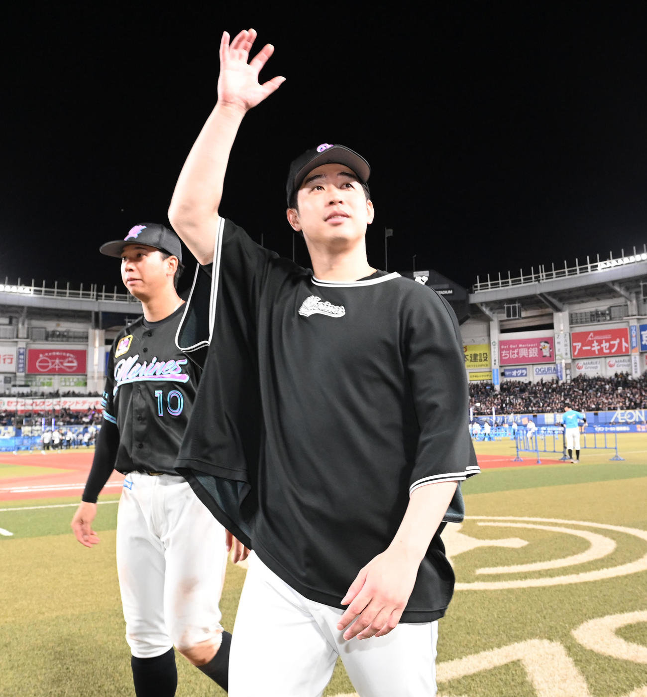 ロッテ対オリックス　勝利投手となりファンに手を振るロッテ種市、左は上田希（撮影・清水貴仁）