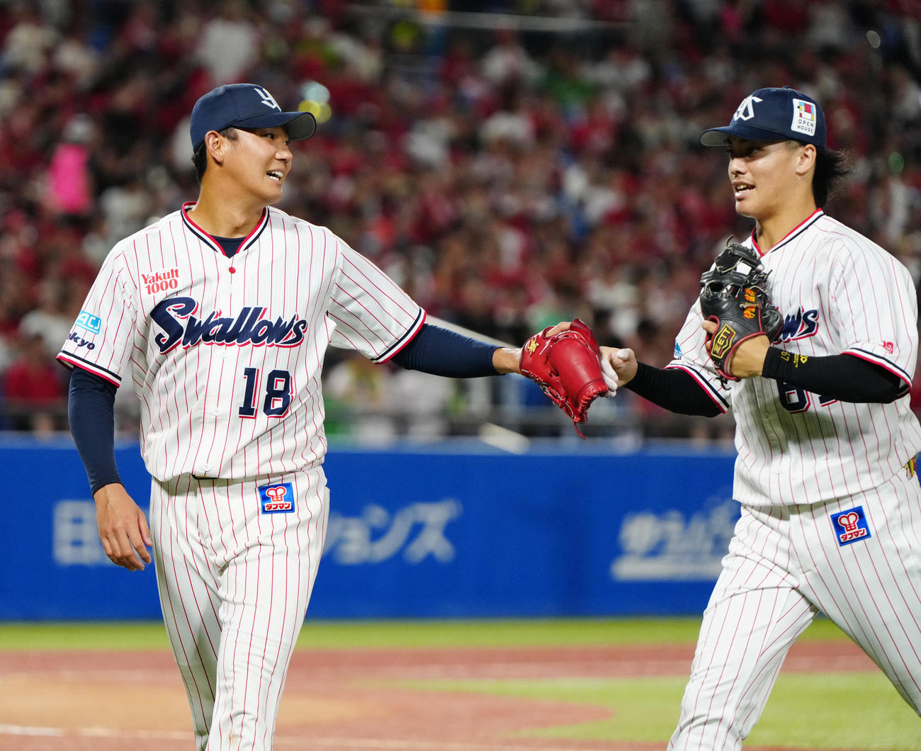 ヤクルト対広島　7回表終了後、ヤクルト遊撃手伊藤（右）とタッチを交わす先発の奥川（撮影・江口和貴）