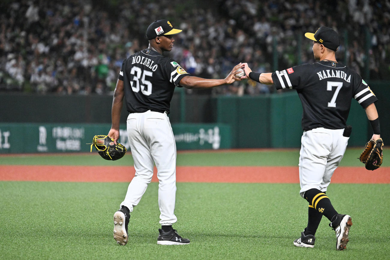 西武対ソフトバンク　完封勝利したソフトバンクのモイネロ（左）は中村晃から記念球を受け取る（撮影・滝沢徹郎）