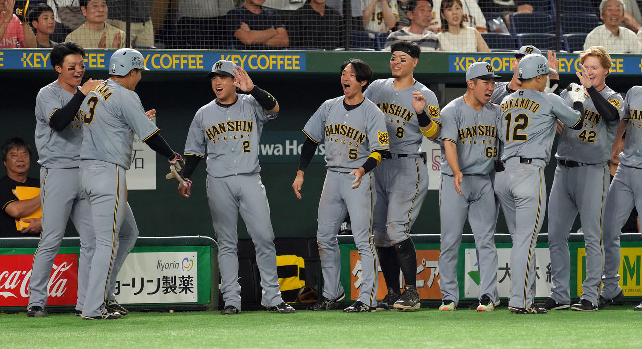 巨人対阪神　11回表阪神2死一塁、2点本塁打を放った坂本誠志郎を迎える佐藤輝（右から2人目）らナイン（撮影・たえ見朱実）