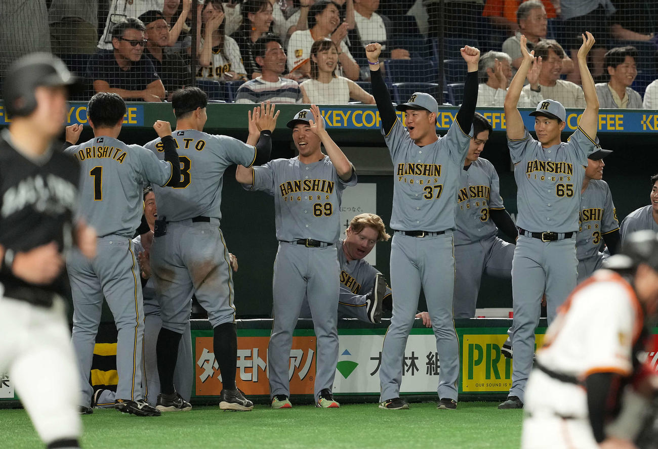 巨人対阪神　11回表阪神2死一塁、坂本の2点本塁打に笑顔を見せる石井（中央）。右から湯浅、及川（撮影・たえ見朱実）