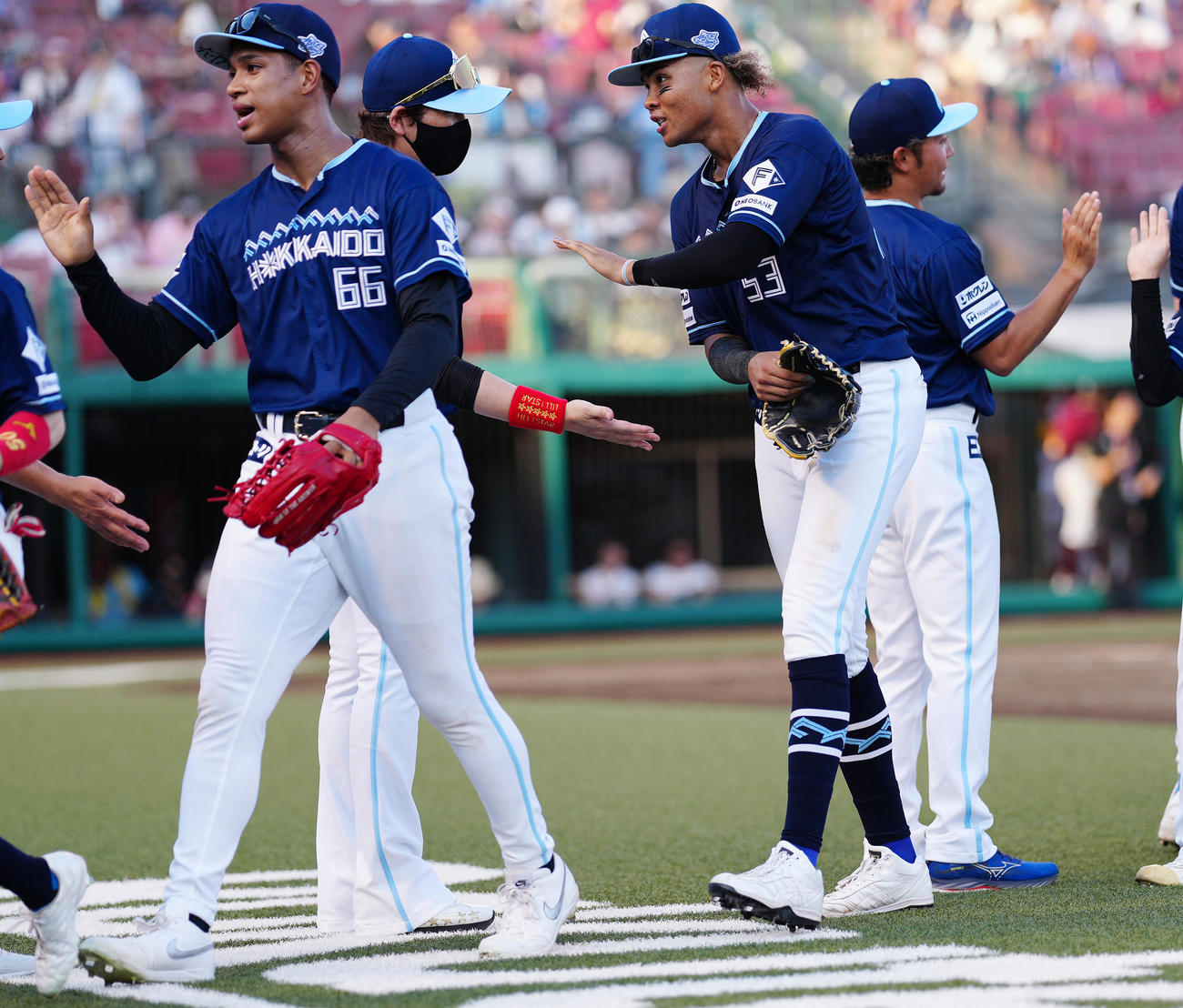 楽天対日本ハム　楽天に勝利し、万波（左）らナインを迎える日本ハム新庄監督（左から2人目）（撮影・鈴木みどり）