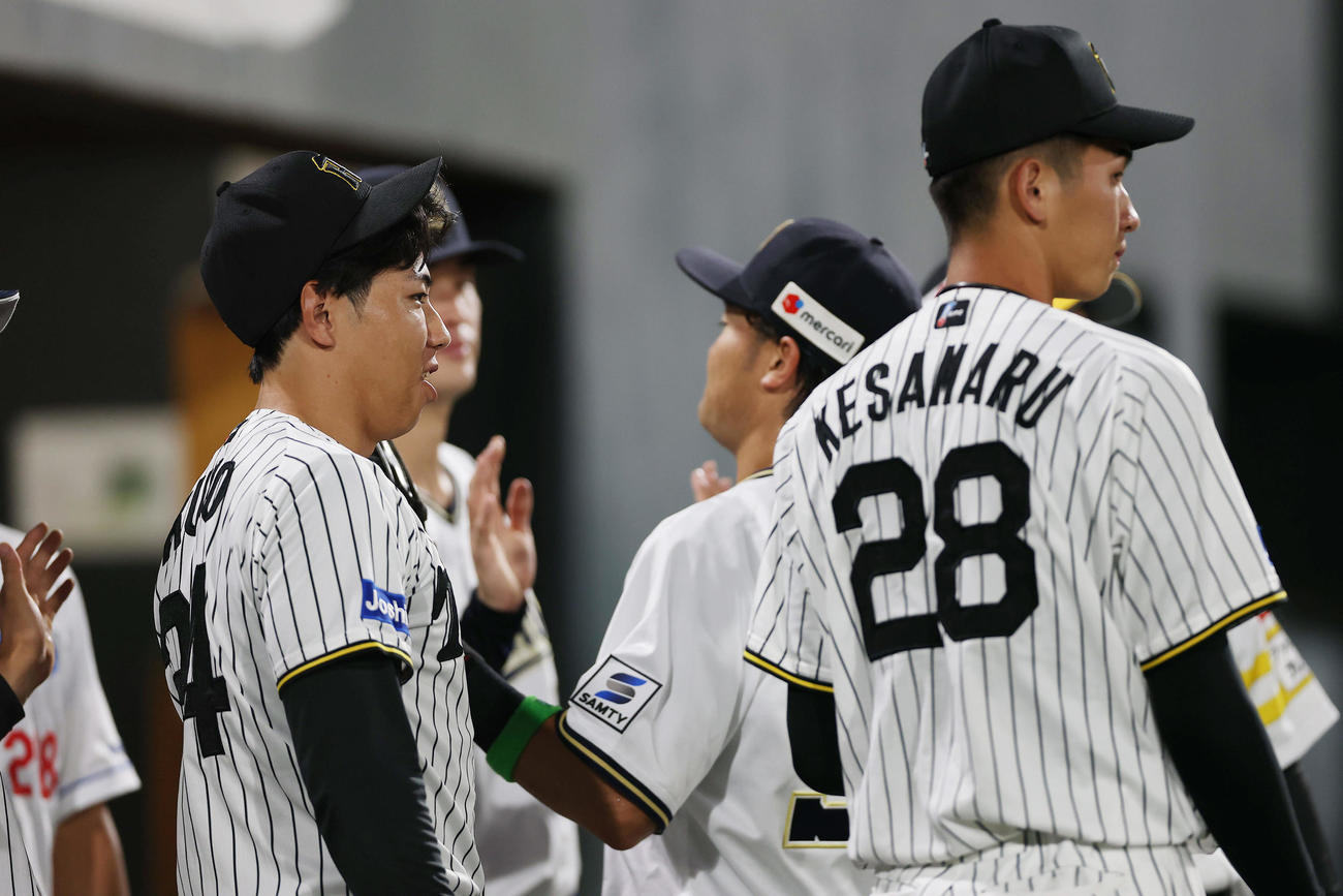全ウ対全イ　6回表を終え、ナインを出迎える全ウ工藤（左）と今朝丸（右）ら（撮影・前田充）