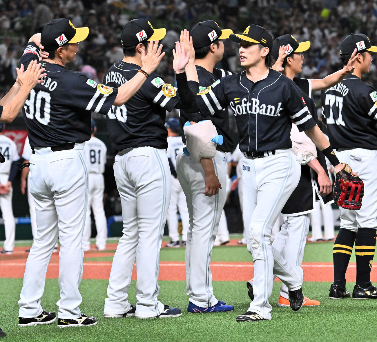 西武対ソフトバンク　試合後、ソフトバンク小久保監督（左）は周東（同4人目）とタッチを交わす（撮影・滝沢徹郎）
