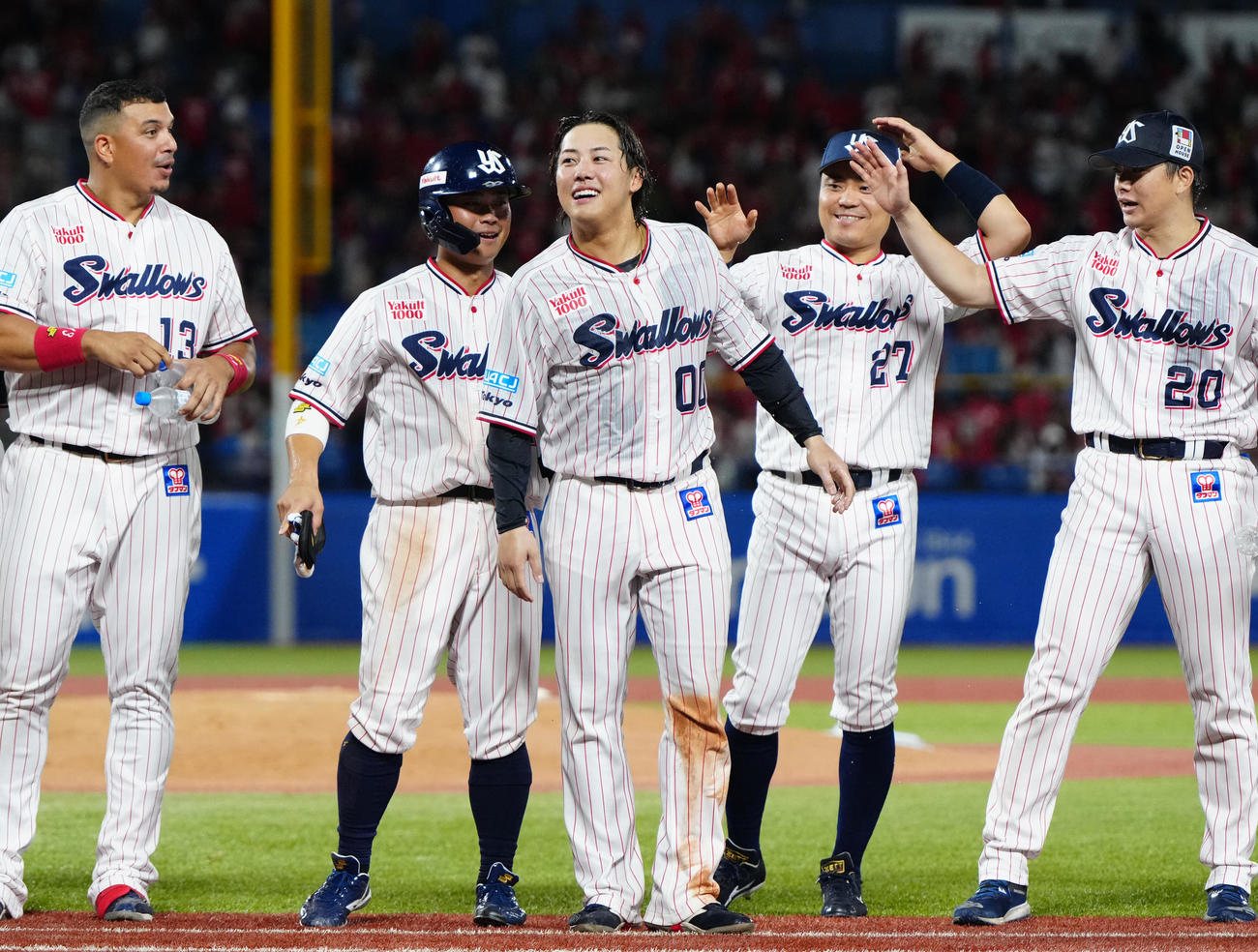 ヤクルト対広島　9回裏ヤクルト2死一、三塁、サヨナラ3点本塁打となりチームメートから祝福される赤羽（中央）（撮影・江口和貴）