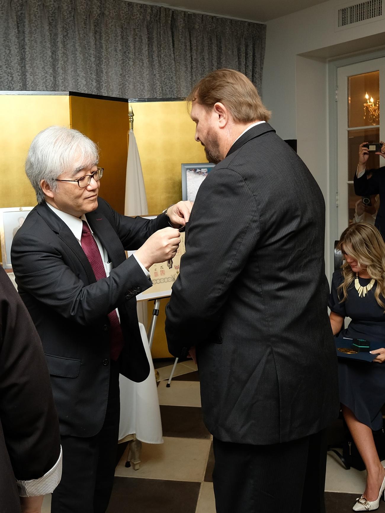 長沼在ヒューストン総領事（左）から、旭日小綬章を授与された元阪神のバース氏（バース氏提供）
