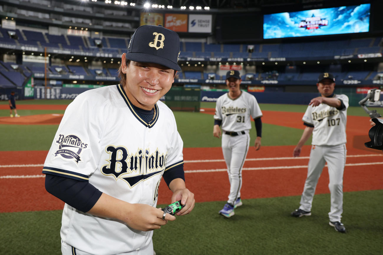 全パ対全セ　オリックス太田と父・暁氏を撮影し満足げな表情を見せる宮城（手前）（撮影・前田充）