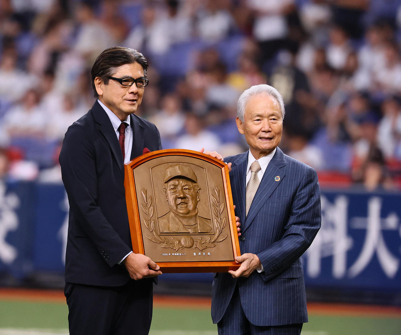 殿堂入り表彰でレリーフをNPB榊原定征コミッショナーから贈られる友寄正人氏（富沢宏哉氏の代理）（撮影・藤尾明華）