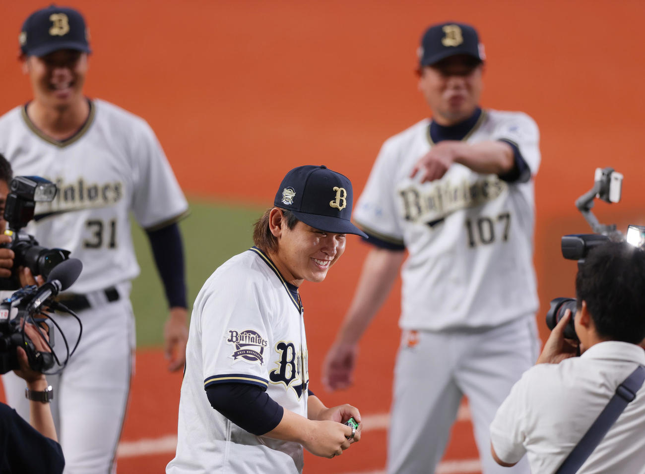 オリックスの太田親子を撮影し笑顔を見せる宮城（手前）（撮影・上山淳一）