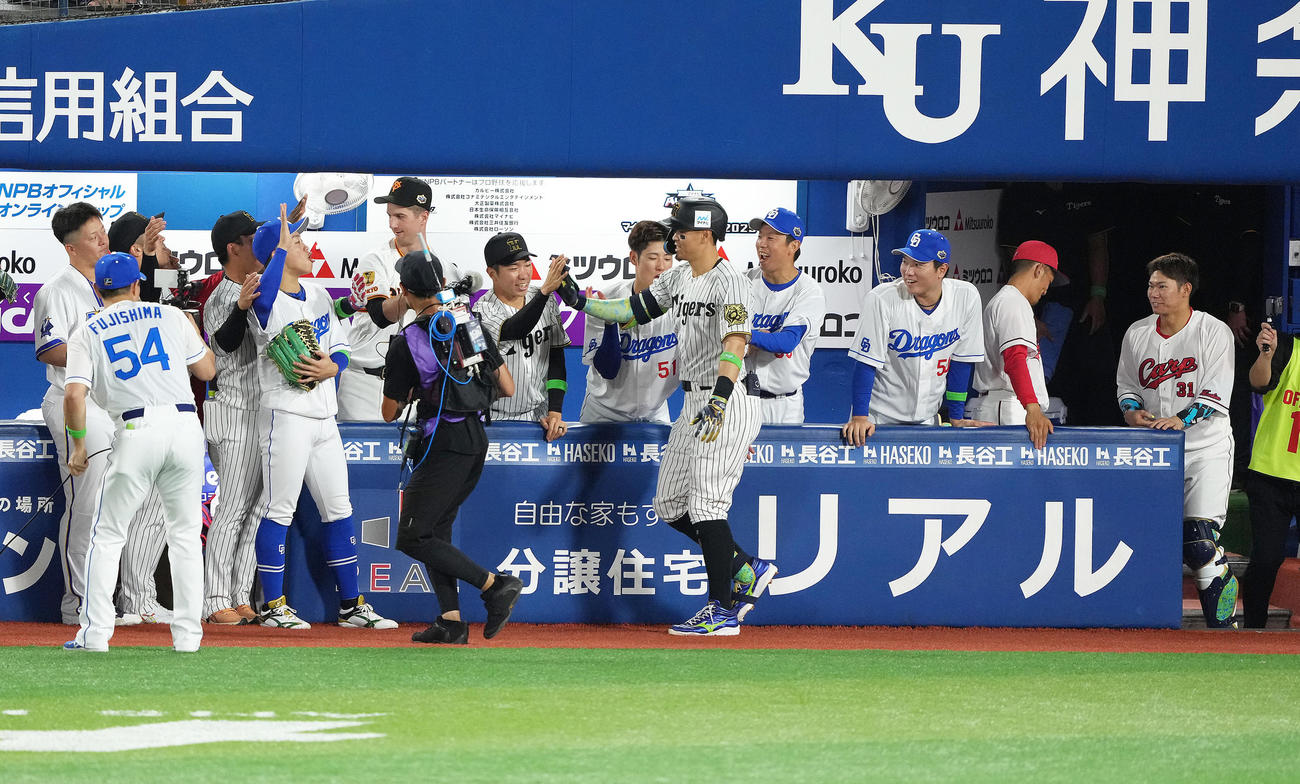 全セ対全パ　5回裏全セ1死、佐藤輝（中央）はソロ本塁打を放ちタッチを交わす（撮影・足立雅史）