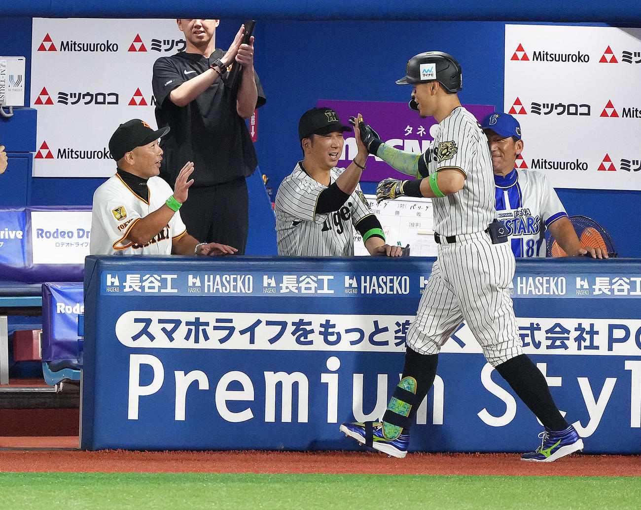 全セ対全パ　5回裏全セ1死、佐藤輝（右）はソロ本塁打を放ち藤川コーチ（中央）らとタッチを交わす（撮影・足立雅史）